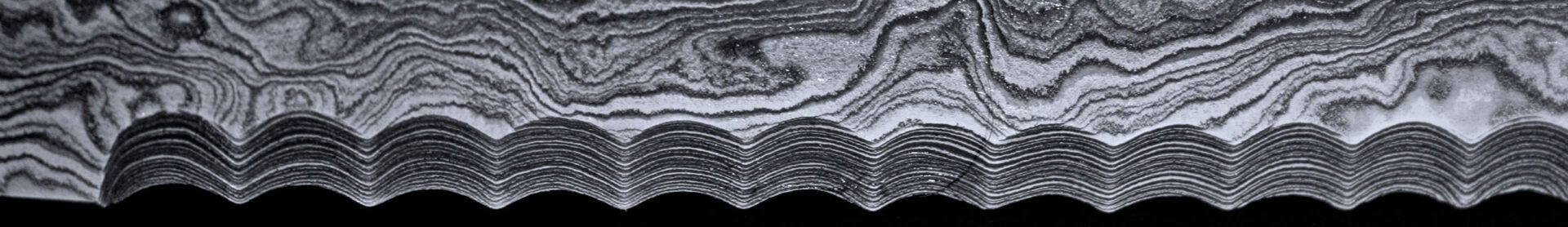 Klingenstruktur des handgeschmiedeten Brotmessers Damaststahl in der Nahaufnahme